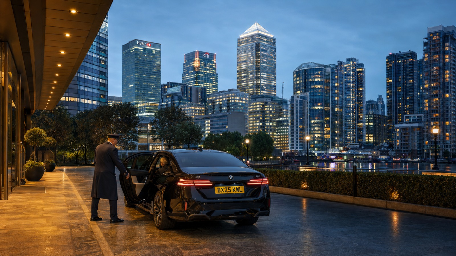Black BMW 5 Series taxi at Canary Wharf hotel entrance with skyline behind at dusk