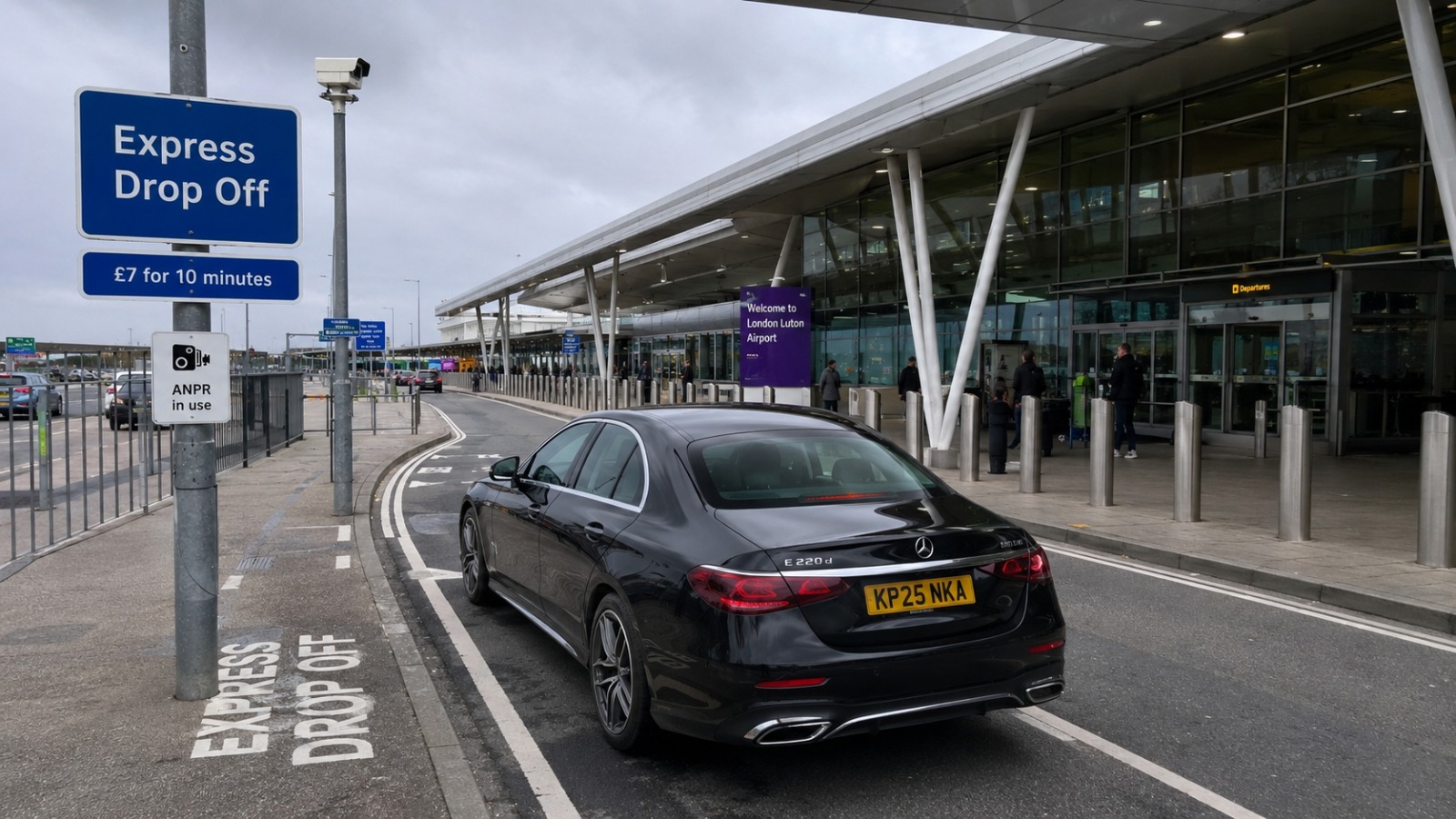 London Luton Airport Express Drop Off Zone signage with ANPR camera and taxi kerbside drop-off.