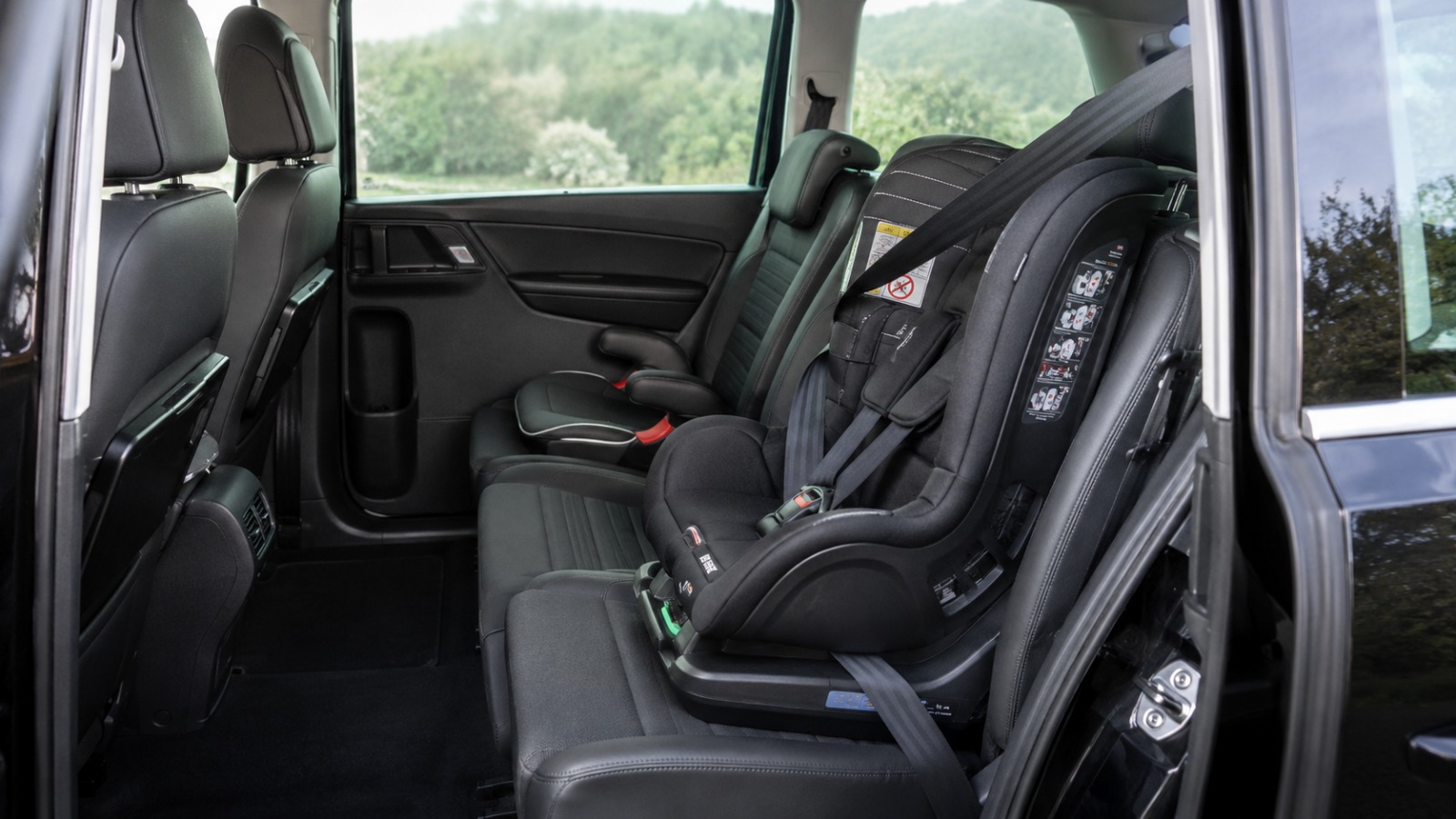 Child seat fitted in the rear of a black VW Sharan MPV6 before an airport transfer