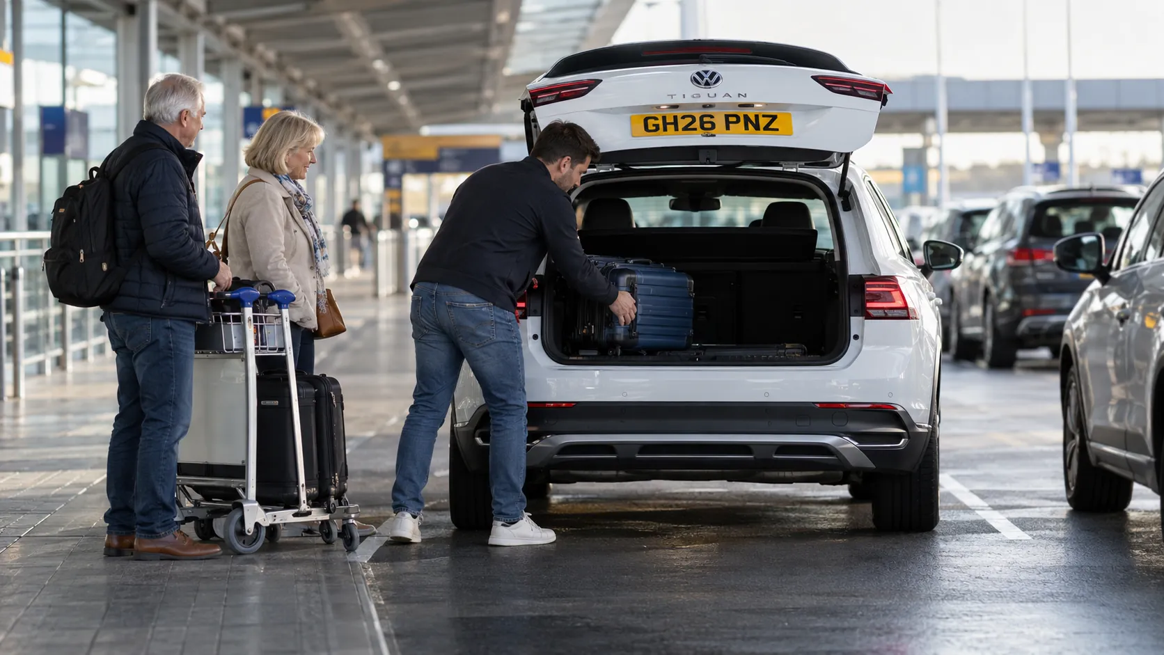 Son loading his parents' cases into a white car at the Gatwick South Terminal pick-up point
